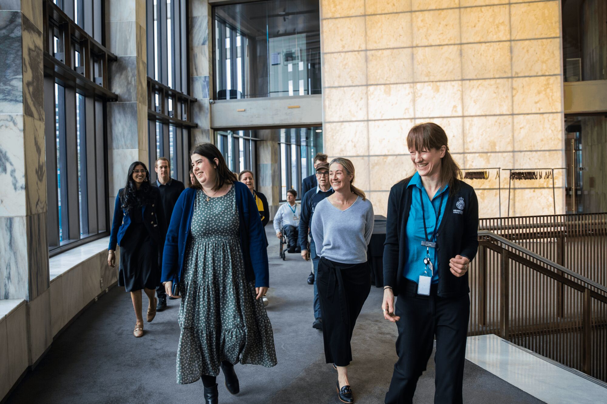 A guide leading a tour group through the marble halls of Parliament House